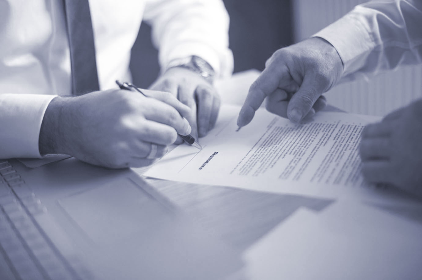 Two people reviewing and signing a document.